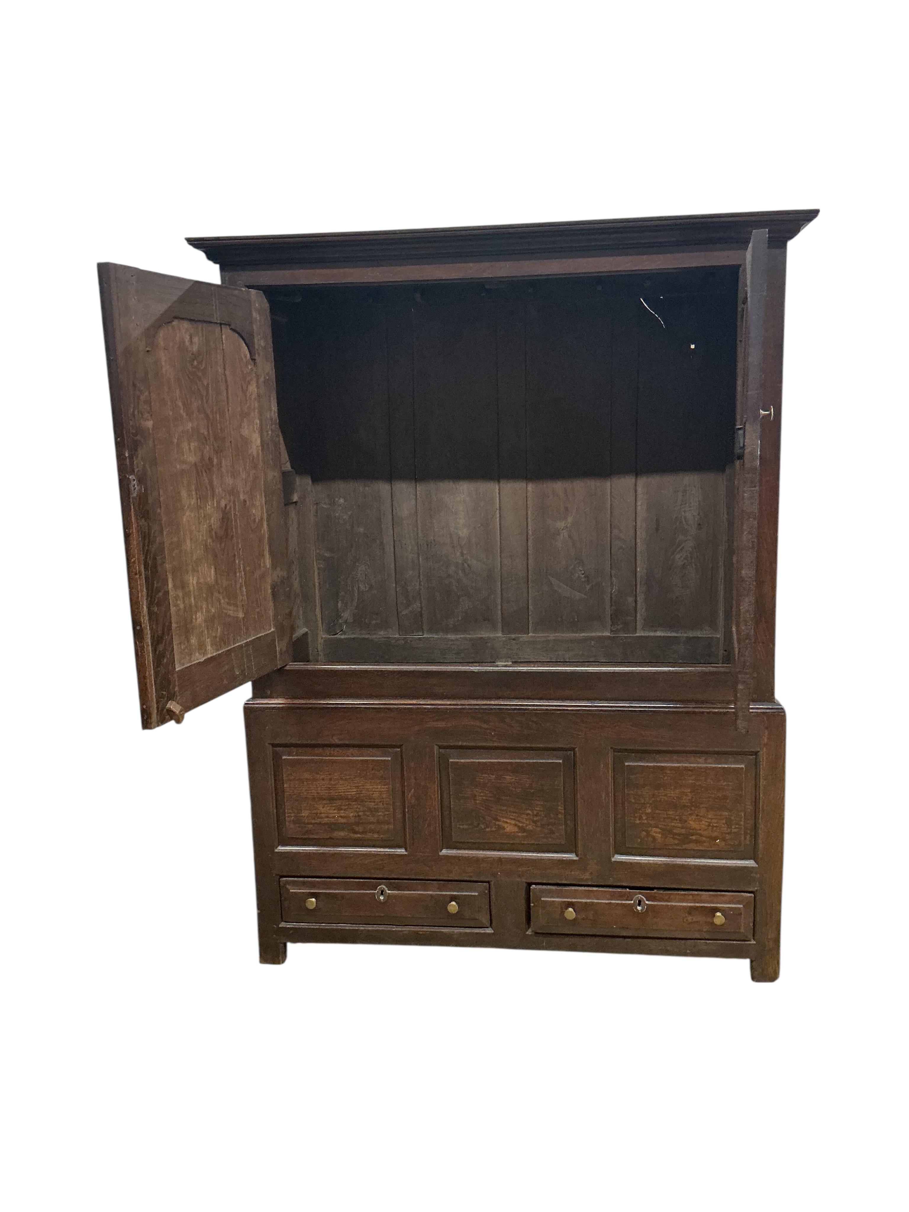 An 18th century oak two part hanging cupboard, width 139cm, depth 55cm, height 181cm